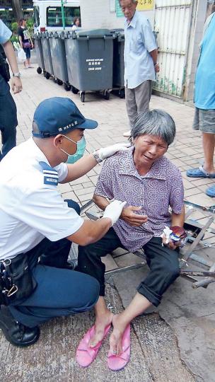 拾荒婦一度因手推車被「充公」鎖進垃圾站內,情緒激動,因她報稱曾跣倒胸口痛,警員召救護員到場為她檢查及送院。(林智傑攝) 拾荒婦一度因手推車被「充公」鎖進垃圾站內,情緒激動,因她報稱曾跣倒胸口痛,警員召救護員到場為她檢查及送院。(林智傑攝)
