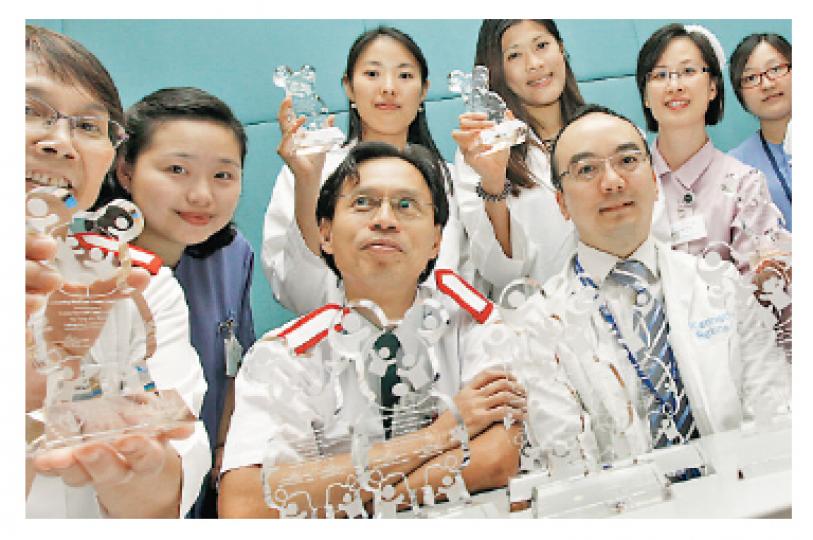 醫管局九龍東聯網眼科部門白內障手術團隊在4年間,將病人等候時間由10年減至1年,獲頒傑出團隊獎。部門主管李啓煌(前右二)及護士長彭永勤(前左二)均感到振奮。(李紹昌攝) 醫管局九龍東聯網眼科部門白內障手術團隊在4年間,將病人等候時間由10年減至1年,獲頒傑出團隊獎。部門主管李啓煌(前右二)及護士長彭永勤(前左二)均感到振奮。(李紹昌攝)
