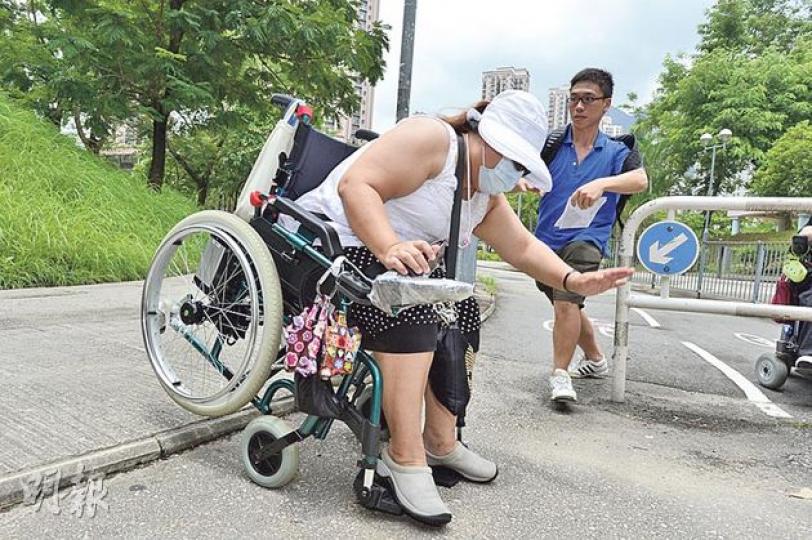 馬鞍山頌安邨一條途經馬鐵站的行人路,下斜路緣高度達5厘米,較1.5厘米的規定超出逾兩倍,坐輪椅的街坊楊女士(前)向記者示範使用該路段,隨即前傾險些絆倒,她表示平日只能在單車路進出,當日現場有單車經過,責罵楊女士及眾人「擋路」。(鄧宗弘攝) 馬鞍山頌安邨一條途經馬鐵站的行人路,下斜路緣高度達5厘米,較1.5厘米的規定超出逾兩倍,坐輪椅的街坊楊女士(前)向記者示範使用該路段,隨即前傾險些絆倒,她表示平日只能在單車路進出,當日現場有單車經過,責罵楊女士及眾人「擋路」。(鄧宗弘攝)