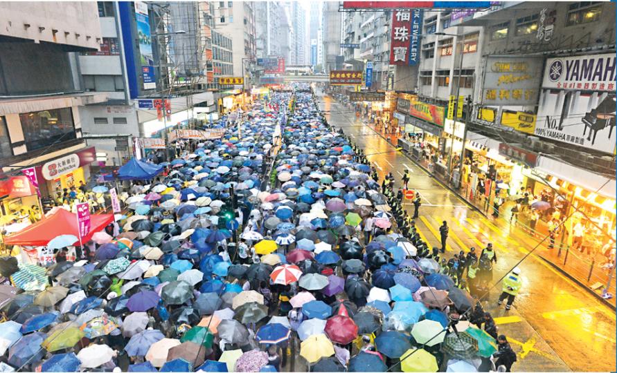 回歸16周年,大批市民在3號風球下仍冒着風雨,撐着雨傘用腳步表達對特區政府的不滿,以及爭取普選的決心,人群在下午5時半擠滿整條銅鑼灣軒尼詩道3條西行線及電車路,最終龍尾於晚上8時半抵達終點中環,整個遊行歷時6小時。(鄧宗弘攝)民陣今年舉辦的七一遊行,大會聲稱有高達43萬名市民冒着3號風球的橫風橫雨,由維園遊行至中環遮打花園,遊行者沿途撐着雨傘,高叫「梁振英下台」、「爭取普選」等口號;警方則指遊行人數為6.6萬。(李紹昌攝)有市民戴上特首梁振英的面具,並為他帶上手扣,諷刺他誠信破產,是中央傀儡,拒 回歸16周年,大批市民在3號風球下仍冒着風雨,撐着雨傘用腳步表達對特區政府的不滿,以及爭取普選的決心,人群在下午5時半擠滿整條銅鑼灣軒尼詩道3條西行線及電車路,最終龍尾於晚上8時半抵達終點中環,整個遊行歷時6小時。(鄧宗弘攝)民陣今年舉辦的七一遊行,大會聲稱有高達43萬名市民冒着3號風球的橫風橫雨,由維園遊行至中環遮打花園,遊行者沿途撐着雨傘,高叫「梁振英下台」、「爭取普選」等口號;警方則指遊行人數為6.6萬。(李紹昌攝)有市民戴上特首梁振英的面具,並為他帶上手扣,諷刺他誠信破產,是中央傀儡,拒