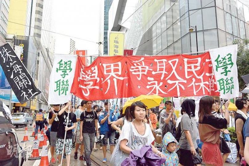 本報民調發現,有近半受訪遊行人士因為爭普選上街,圖為遊行的學聯高舉爭取民主的橫額。(張景寧攝) 本報民調發現,有近半受訪遊行人士因為爭普選上街,圖為遊行的學聯高舉爭取民主的橫額。(張景寧攝)