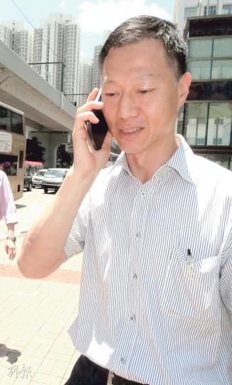 消防總隊目李德其（圖）去年底在消防局內以水喉射同袍，其後被控兩項襲擊罪，他昨應訊後與同袍分開離開法院，其間一直緊握電話講話，未有理會記者拍攝。（陳倢朗攝）