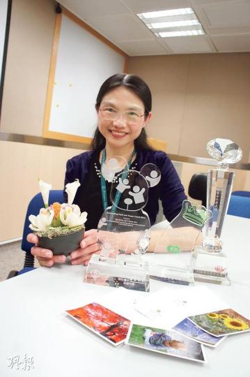 獲得今年醫管局最佳員工獎的瑪嘉烈病人聯絡主任蕭錦綉,為減輕病人家屬傷痛,騰出公餘時間相伴。不少家屬送卡、送禮物答謝,蕭姑娘特別展示一名老婆婆送贈的手工盆栽。(梁杏怡攝) 獲得今年醫管局最佳員工獎的瑪嘉烈病人聯絡主任蕭錦綉,為減輕病人家屬傷痛,騰出公餘時間相伴。不少家屬送卡、送禮物答謝,蕭姑娘特別展示一名老婆婆送贈的手工盆栽。(梁杏怡攝)