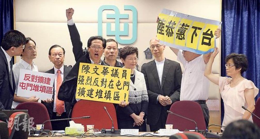 屯門區議會昨召開特別會議,討論政府申請撥款研究擴建屯門堆填區。會議開始前,議員陳文華(左四)及陳雲生(右二)高舉橫額及叫口號,反對擴建堆填區,又要求環境局副局長陸恭蕙下台。在場的政務司長林鄭月娥(右四)及環境局長黃錦星(右三)離席暫避。(余俊亮攝)(明報製圖) 屯門區議會昨召開特別會議,討論政府申請撥款研究擴建屯門堆填區。會議開始前,議員陳文華(左四)及陳雲生(右二)高舉橫額及叫口號,反對擴建堆填區,又要求環境局副局長陸恭蕙下台。在場的政務司長林鄭月娥(右四)及環境局長黃錦星(右三)離席暫避。(余俊亮攝)(明報製圖)