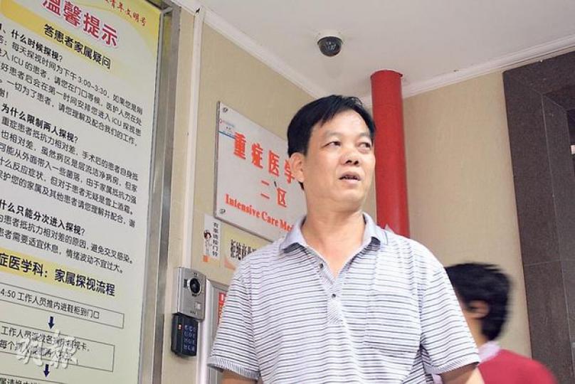 內地部門昨派出人員，到確診H7N9禽流感女病人陳冬祝的家禽檔所在地惠州市博羅縣墟鎮新市場消毒，身穿防護衣物的人員於女病人的店外噴消毒藥水。有街坊稱，當局並未進入店內消毒，只以高壓水炮清洗大門。（余俊亮攝）
