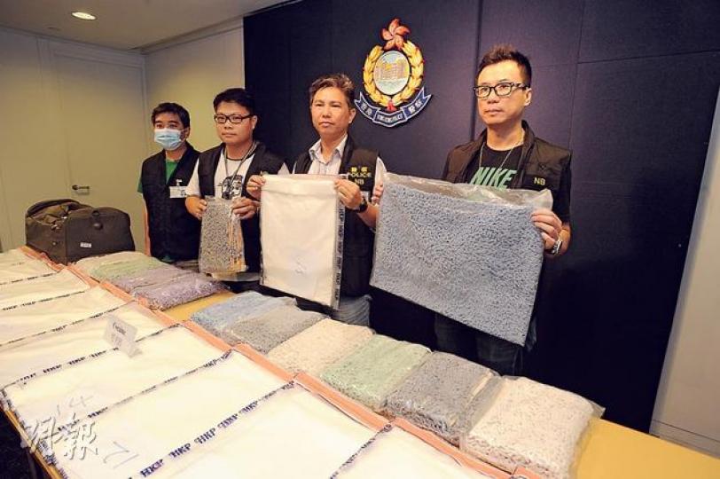 警方毒品調查科高級督察趙志強（右二）手持藏在其中一張地氈夾層的兩公斤可卡因，其他探員展示經改裝後各種顏色的地氈。（樊銳昌攝）
