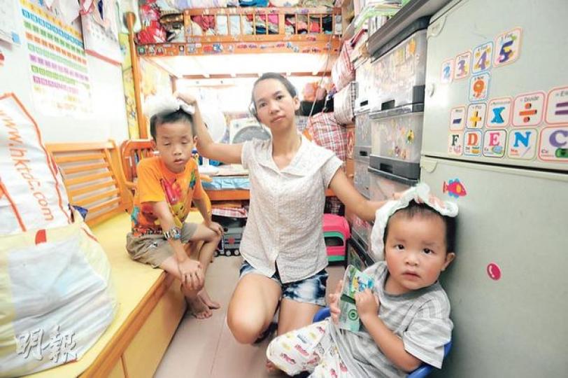 張太(中)與丈夫育有3名子女,以約3000元月租觀塘一個約100呎劏房,房間僅有的窗被碌架牀遮擋,令房內非常悶熱,要不時為兩子抹汗。她說為了省冷氣費,平日會到商場「避暑」至晚上才回家。(尹錦恩攝) 張太(中)與丈夫育有3名子女,以約3000元月租觀塘一個約100呎劏房,房間僅有的窗被碌架牀遮擋,令房內非常悶熱,要不時為兩子抹汗。她說為了省冷氣費,平日會到商場「避暑」至晚上才回家。(尹錦恩攝)
