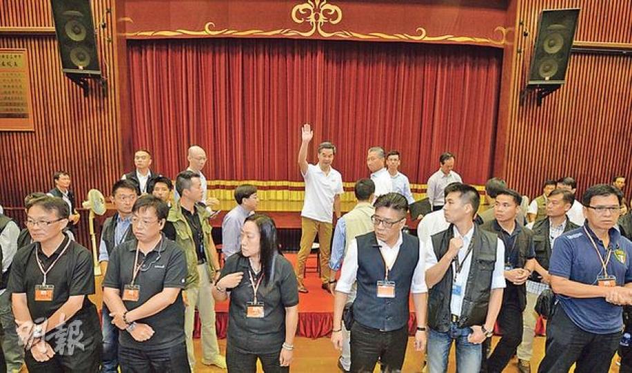特首梁振英(後排中間揮手者)昨到觀塘與市民見面,在論壇將近完結時,人民力量在會場後方叫喊,令在場保安及警方、包括保護要員組十分緊張,隨即在台前築起三重防線,以防混亂;場內保安部署,遠較上周天水圍論壇嚴密。(盧翊銘攝)3名帶濃厚口音長者,手持寫有「818網民自發『撐CY 撐警察 護法治』宣示集會」及挺政府口號的「貓紙」,耐心聽戴黑帽女子(右)講解。長者稱自發出席,在女子手勢示意下,否認有收取車馬費和有專車接送。(張煒明攝) 特首梁振英(後排中間揮手者)昨到觀塘與市民見面,在論壇將近完結時,人民力量在會場後方叫喊,令在場保安及警方、包括保護要員組十分緊張,隨即在台前築起三重防線,以防混亂;場內保安部署,遠較上周天水圍論壇嚴密。(盧翊銘攝)3名帶濃厚口音長者,手持寫有「818網民自發『撐CY 撐警察 護法治』宣示集會」及挺政府口號的「貓紙」,耐心聽戴黑帽女子(右)講解。長者稱自發出席,在女子手勢示意下,否認有收取車馬費和有專車接送。(張煒明攝)