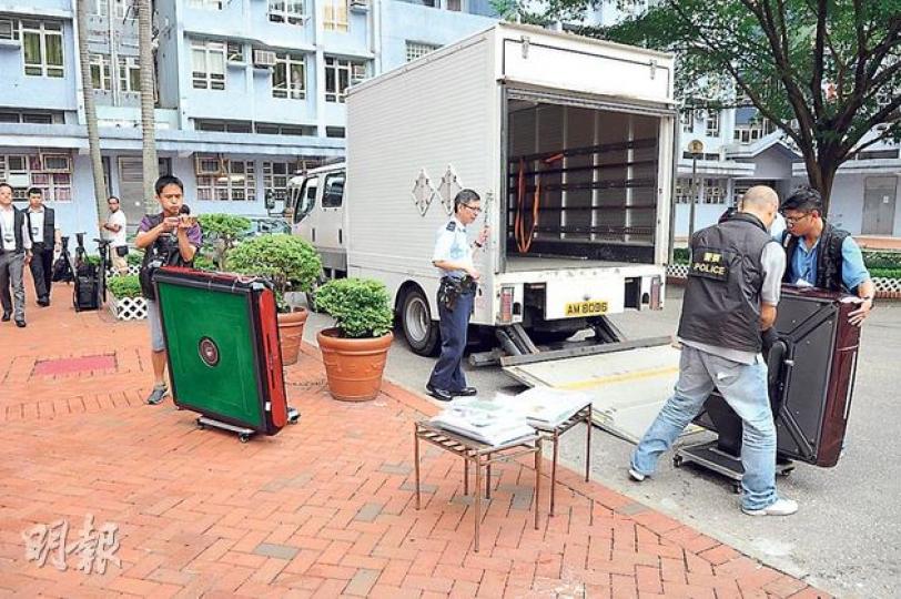 警員在搗破的「居屋賭場」檢走3張電動麻將枱、6副麻將及賭款籌碼等。（丁灝嵐攝）警員拘捕涉嫌洗黑錢的唐姓女子（右），她涉利用3個私人銀行戶口及兩個公司戶口清洗約1000萬元黑錢。（丁灝嵐攝）被捕的40歲周姓男子（右），涉嫌在租用的居屋單位經營非法賭檔。（丁灝嵐攝）