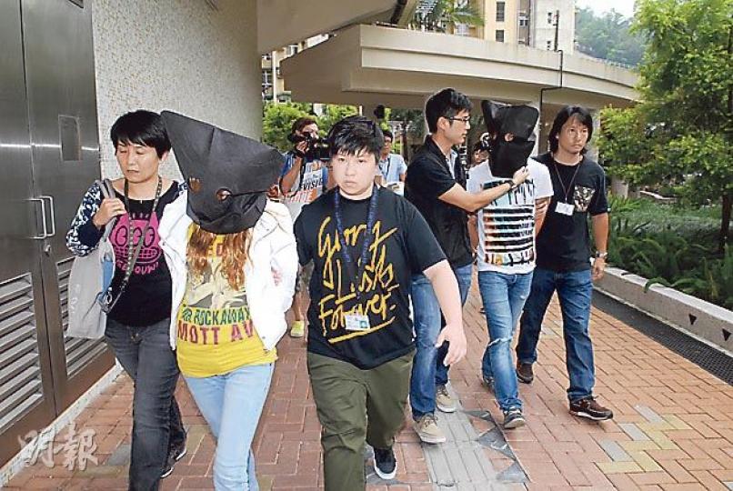 涉多宗車內盜竊被捕的情侶，昨同被黑布蒙頭，由警員押返將軍澳善明邨寓所搜證。（伍浦鋒攝）