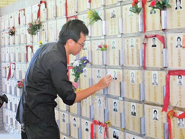 菲律賓人質事件3周年,謝廷駿的家屬到鑽石山墳場拜祭,弟弟謝志恆獻上鮮花並將龕位上的灰塵抹走。(周翠怡攝) 菲律賓人質事件3周年,謝廷駿的家屬到鑽石山墳場拜祭,弟弟謝志恆獻上鮮花並將龕位上的灰塵抹走。(周翠怡攝)