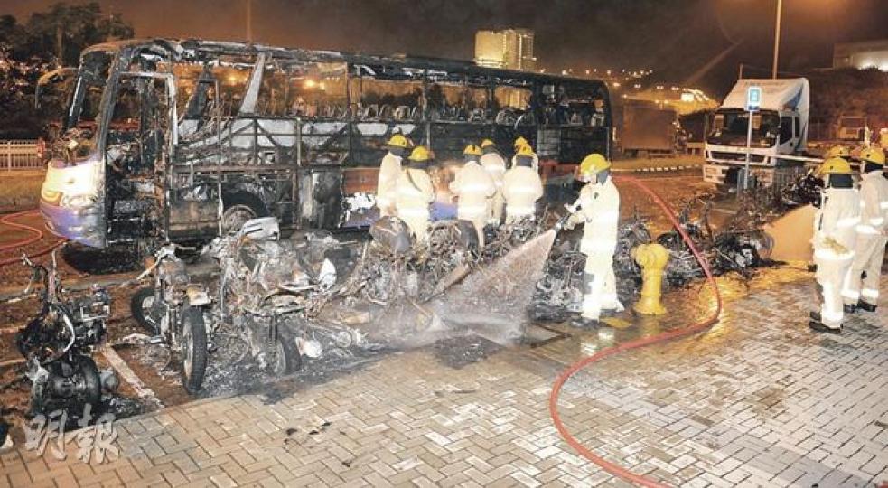 青衣縱火燒車案共1輛旅遊巴及21輛電單車被嚴重焚毁,消防員將火救熄後繼續射水以防死灰復燃。(蔡方山攝) 青衣縱火燒車案共1輛旅遊巴及21輛電單車被嚴重焚毁,消防員將火救熄後繼續射水以防死灰復燃。(蔡方山攝)