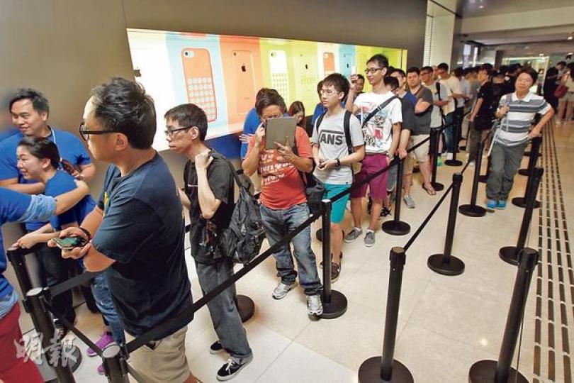 大批預訂了iPhone 5s和iPhone 5c的消費者，昨清晨已到中環國際金融中心蘋果專門店外排隊，等候取機。（李紹昌攝）有人在中環國際金融中心的蘋果專門店外即場收購iPhone 5s（持鈔票者），向剛從專門店買入手機的市民繳付現金。（李紹昌攝）