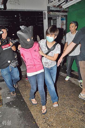 涉販毒被捕女子(蒙頭者)由女警押走,在旁一名中年男子(右一)不斷叫喊﹕「老婆唔使驚,我會保釋你! 」(伍浦鋒攝) 涉販毒被捕女子(蒙頭者)由女警押走,在旁一名中年男子(右一)不斷叫喊﹕「老婆唔使驚,我會保釋你! 」(伍浦鋒攝)