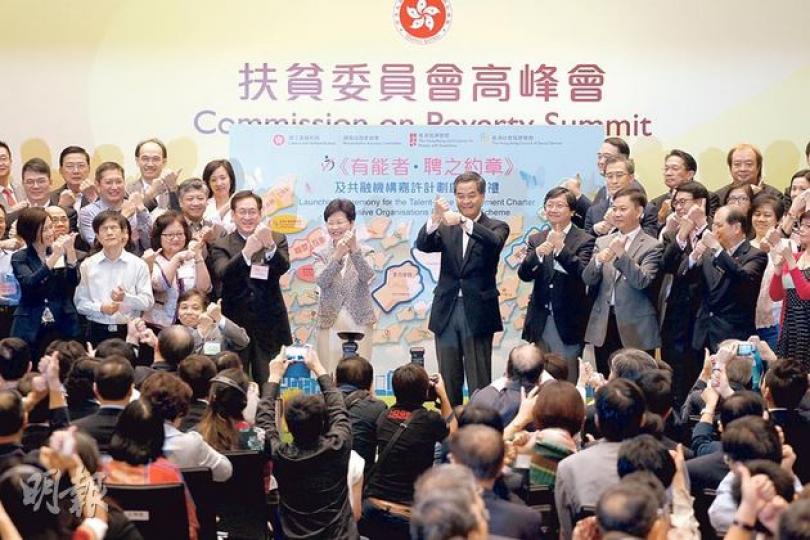 扶貧高峰會除了公布貧窮線數據,又為協助殘疾人士就業的《有能者•聘之約計》舉行典禮,並要求台上人士舉起左手拇指,放在右手拳頭上,以手語表達「撐起」的意思,但特首梁振英卻調亂左右手,未知有否影響手語意思。(李紹昌攝)立法會議員梁國雄(紅衣者)在昨日的扶貧高峰會中,一度高舉示威標語及叫口號,向特首梁振英(中)抗議,隨即被12名保安包圍拉離現場,令他在開場不足5分鐘已被逐。(李紹昌攝) 扶貧高峰會除了公布貧窮線數據,又為協助殘疾人士就業的《有能者•聘之約計》舉行典禮,並要求台上人士舉起左手拇指,放在右手拳頭上,以手語表達「撐起」的意思,但特首梁振英卻調亂左右手,未知有否影響手語意思。(李紹昌攝)立法會議員梁國雄(紅衣者)在昨日的扶貧高峰會中,一度高舉示威標語及叫口號,向特首梁振英(中)抗議,隨即被12名保安包圍拉離現場,令他在開場不足5分鐘已被逐。(李紹昌攝)