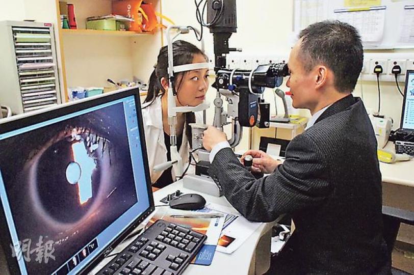 新界東聯網眼科及視覺科學系統籌楊樂旼(右)表示,已增聘兩名駐院醫生,以及增設1間手術室及1間診症室,預計一年內可接收多4200宗新症,他昨日在診症室內模擬為病人驗眼。(梁杏怡攝) 新界東聯網眼科及視覺科學系統籌楊樂旼(右)表示,已增聘兩名駐院醫生,以及增設1間手術室及1間診症室,預計一年內可接收多4200宗新症,他昨日在診症室內模擬為病人驗眼。(梁杏怡攝)