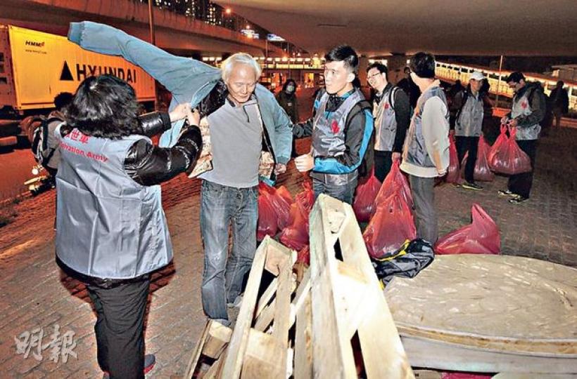 天文台昨日發出今年入冬首個寒冷天氣警告，提醒市民禦寒之餘，亦不忘關心身邊人。救世軍昨晚派人到天橋底派發禦寒衣服予露宿者，以示關懷。（李澤彤攝）