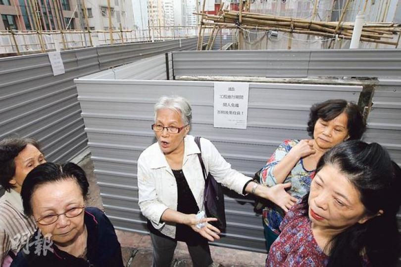 灣仔祥樂大樓參與市建局「樓宇更新大行動」維修,但持整幢大樓四分之一單位連天台業權的「落釘」財團,在天台封起圍板,阻止承建商開工。法團主席(白衣者)陳淑菁及多名業主非常不滿,並因延遲工程,要面臨承建商索償380萬元,擔心影響樓宇結構。(明報記者攝)持有大樓24個單位的財團亦同時擁有天台業權,稱工人未經同意破壞天台,法團又未有正式通知會在天台施工,故以圍板封住天台,派出兩人守衛,不讓工人進入。(明報記者攝)兩名「天台安全督導員」稱,並非要阻礙工程,只是負責監察工人施工有否違規,其中一人尹先生(右圖) 灣仔祥樂大樓參與市建局「樓宇更新大行動」維修,但持整幢大樓四分之一單位連天台業權的「落釘」財團,在天台封起圍板,阻止承建商開工。法團主席(白衣者)陳淑菁及多名業主非常不滿,並因延遲工程,要面臨承建商索償380萬元,擔心影響樓宇結構。(明報記者攝)持有大樓24個單位的財團亦同時擁有天台業權,稱工人未經同意破壞天台,法團又未有正式通知會在天台施工,故以圍板封住天台,派出兩人守衛,不讓工人進入。(明報記者攝)兩名「天台安全督導員」稱,並非要阻礙工程,只是負責監察工人施工有否違規,其中一人尹先生(右圖)