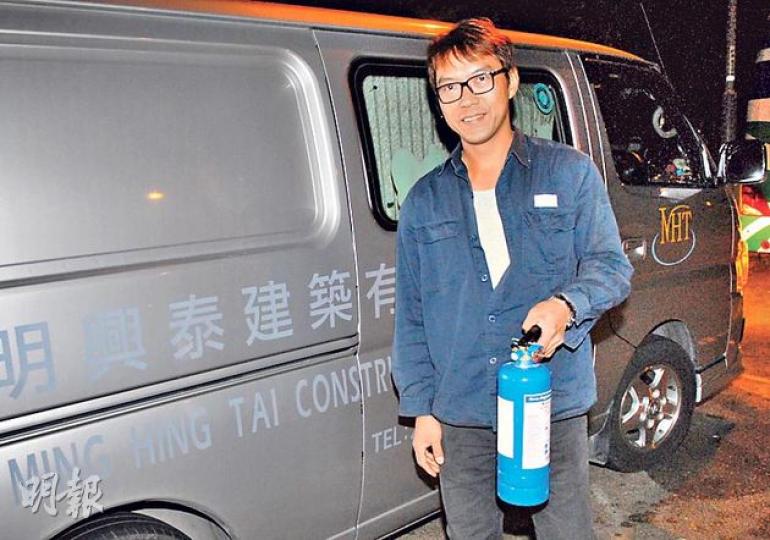 獲網民大讚是救火英雄的客貨車司機龍先生,在客貨車旁展示曾用於救火的滅火筒,並謙稱只是盡一點力幫人。(伍浦鋒攝) 獲網民大讚是救火英雄的客貨車司機龍先生,在客貨車旁展示曾用於救火的滅火筒,並謙稱只是盡一點力幫人。(伍浦鋒攝)