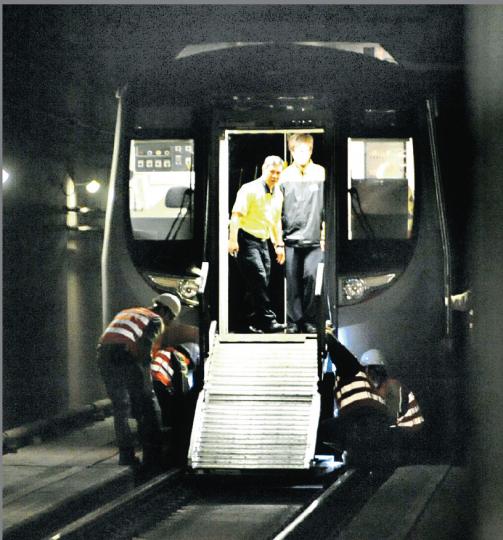 出事列車在行車管道煞停後,港鐵職員在車頭拉出金屬梯疏散乘客。其後工程人員拿着電筒,到列車車底檢查。(衛永康攝) 出事列車在行車管道煞停後,港鐵職員在車頭拉出金屬梯疏散乘客。其後工程人員拿着電筒,到列車車底檢查。(衛永康攝)