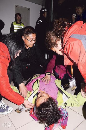 有女團友不滿警方阻止她用手捉住旅行社代表,隨即「大字形」倒地大哭,半分鐘後突停了哭聲,其團友即上前猛搖,惟無法喚醒她,警方遂召救護車將她送院治理。(湯俊彥攝) 有女團友不滿警方阻止她用手捉住旅行社代表,隨即「大字形」倒地大哭,半分鐘後突停了哭聲,其團友即上前猛搖,惟無法喚醒她,警方遂召救護車將她送院治理。(湯俊彥攝)