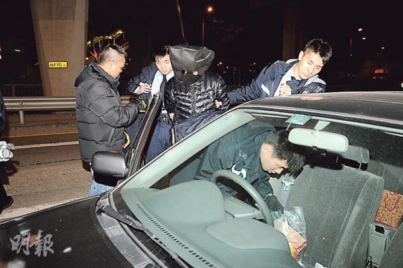警員將神志不清的「索K」男子黑布蒙頭押返其私家車搜查。(蔡方山攝) 警員將神志不清的「索K」男子黑布蒙頭押返其私家車搜查。(蔡方山攝)