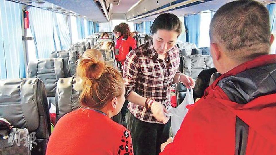 無限極職員(中)昨一度登上旅遊巴,為堅拒離港的旅客提供飯盒充飢。(林智傑攝)部分昨早與旅行社達成協議的遊客(圖中紅衣者),昨沿落馬洲口岸過境,無限極職員陳立新(圖左灰衣者)全程陪同。(林智傑攝) 無限極職員(中)昨一度登上旅遊巴,為堅拒離港的旅客提供飯盒充飢。(林智傑攝)部分昨早與旅行社達成協議的遊客(圖中紅衣者),昨沿落馬洲口岸過境,無限極職員陳立新(圖左灰衣者)全程陪同。(林智傑攝)