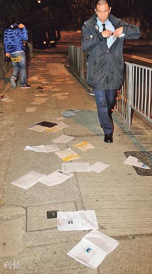 西環堅道近西摩道街頭昨凌晨散佈了數百張文件,當中包括香港科技專上書院學生及舊生的大量個人資料,有途人發現文件後報警,警員到場調查兼將文件逐份檢走。(蔡方山攝) 西環堅道近西摩道街頭昨凌晨散佈了數百張文件,當中包括香港科技專上書院學生及舊生的大量個人資料,有途人發現文件後報警,警員到場調查兼將文件逐份檢走。(蔡方山攝)