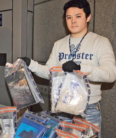 警員展示在大圍一個住宅單位檢獲的「有料」相片(左)及其他懷疑毒品(右)。(蔡方山攝) 警員展示在大圍一個住宅單位檢獲的「有料」相片(左)及其他懷疑毒品(右)。(蔡方山攝)