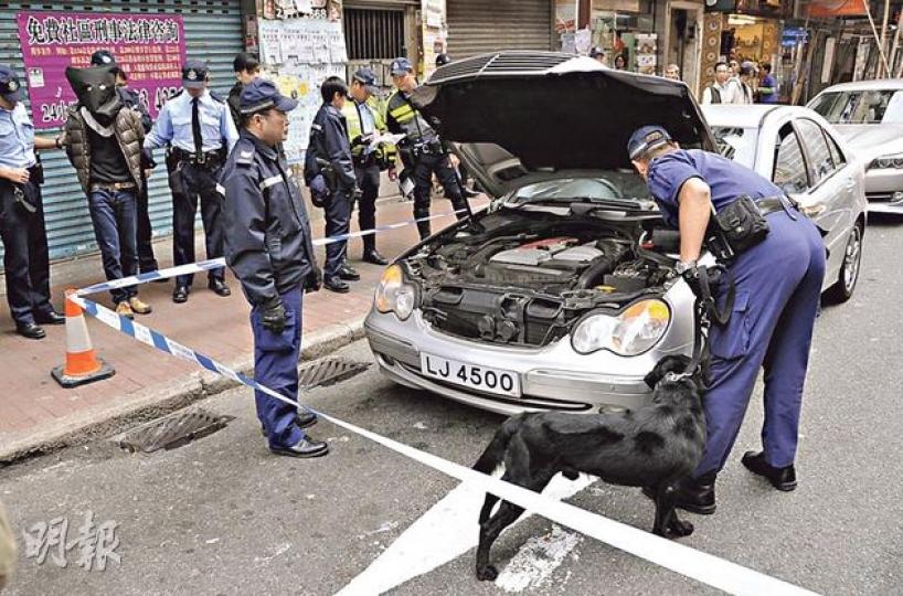 警員昨派緝毒犬在懷疑藏毒青年的座駕上搜查,黑布蒙頭(後排左二)的疑犯一直在旁。(湯俊彥攝) 警員昨派緝毒犬在懷疑藏毒青年的座駕上搜查,黑布蒙頭(後排左二)的疑犯一直在旁。(湯俊彥攝)