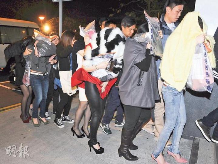 涉嫌於蘭桂坊兜客賣淫的9名女子全部衣著光鮮，打扮如辦公室女郎，亦不乏身穿名牌衣物者。（樊銳昌攝）警方經長時間部署，「放蛇」洋警官取得賣淫集團王姓女主腦（前左）信任。她前晚落網時雙手掩臉，由探員帶署調查。（樊銳昌攝）