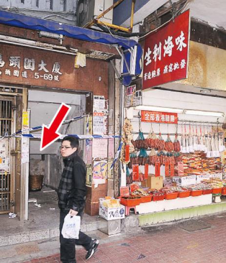 被爆竊的「生利海味」旁是唐樓馬頭圍大廈的樓梯，警員在樓梯底一處發現一個直徑1.5呎的洞（箭嘴示附近，圖中看不見），懷疑賊人沿破洞入店舖搜掠。（湯俊彥攝）