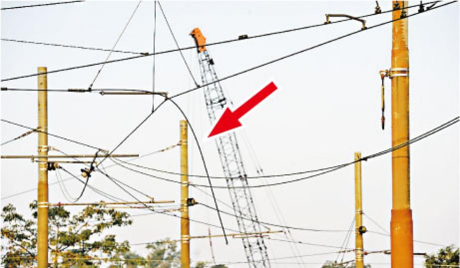 輕鐵天水圍塘坊村站範圍的一段架空電纜,疑因絕緣體損毁致一條電纜鬆脫垂下(箭嘴示),電纜觸碰到途徑列車,令車頂出現火花及冒煙而需暫停行駛。(蔡方山攝) 輕鐵天水圍塘坊村站範圍的一段架空電纜,疑因絕緣體損毁致一條電纜鬆脫垂下(箭嘴示),電纜觸碰到途徑列車,令車頂出現火花及冒煙而需暫停行駛。(蔡方山攝)