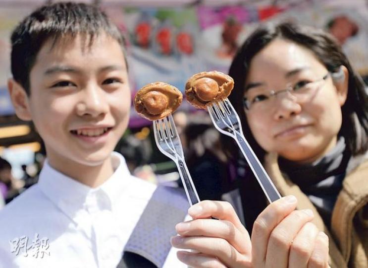 陳小姐(右)昨帶同14歲兒子到維園行年宵,他們買了鮑魚和雞煲翅,陳小姐認為年宵賣鮑魚只是噱頭,但總比每年賣魚蛋、燒賣來得多元化。(余俊亮攝) 陳小姐(右)昨帶同14歲兒子到維園行年宵,他們買了鮑魚和雞煲翅,陳小姐認為年宵賣鮑魚只是噱頭,但總比每年賣魚蛋、燒賣來得多元化。(余俊亮攝)