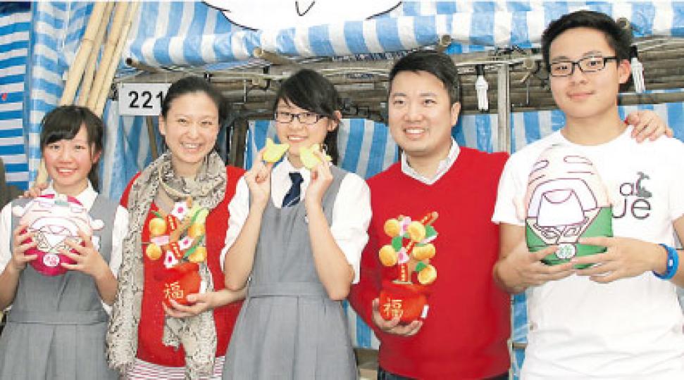 王賢訊(右二)與太太Vincci(左二)及一班中學生在年宵攤位落力推銷。(攝影/記者:林蘊兒) 王賢訊(右二)與太太Vincci(左二)及一班中學生在年宵攤位落力推銷。(攝影/記者:林蘊兒)