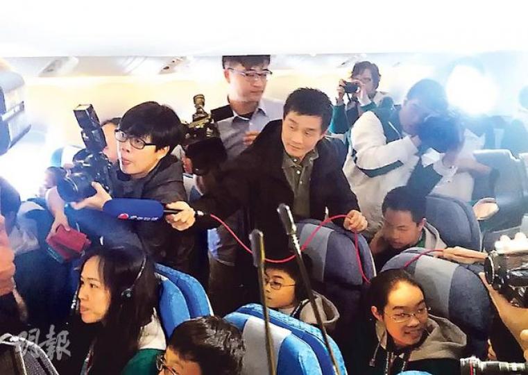 噚日國泰邀請約20多個記者上飛機採訪低收入家庭第一次搭飛機,不過機艙環境擠迫,記者難埋身,好彩幫梁振英開路嘅G4警員(中間持咪者)肯幫電視台記者舉咪收音。(梁卓怡攝) 噚日國泰邀請約20多個記者上飛機採訪低收入家庭第一次搭飛機,不過機艙環境擠迫,記者難埋身,好彩幫梁振英開路嘅G4警員(中間持咪者)肯幫電視台記者舉咪收音。(梁卓怡攝)
