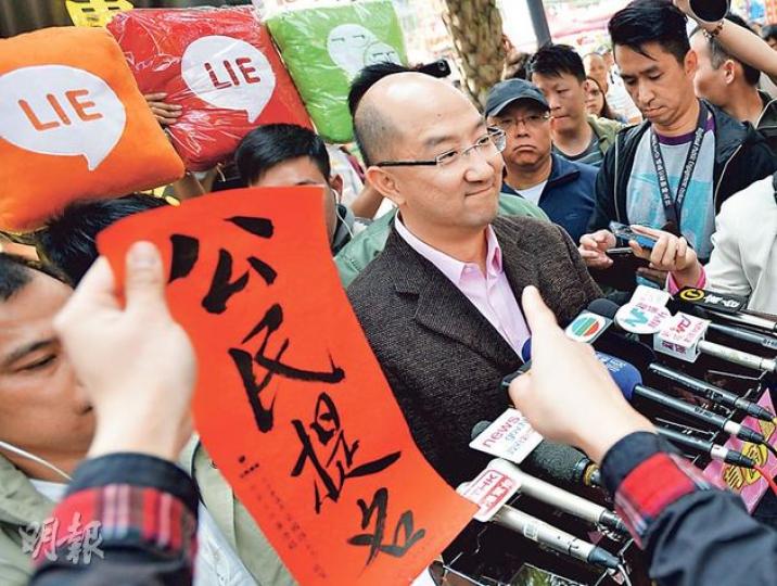 政制及內地事務局長譚志源昨日到維園年宵市場向市民派發政改宣傳單張,其間有市民指着他,高呼要求公民提名。(盧翊銘攝) 政制及內地事務局長譚志源昨日到維園年宵市場向市民派發政改宣傳單張,其間有市民指着他,高呼要求公民提名。(盧翊銘攝)