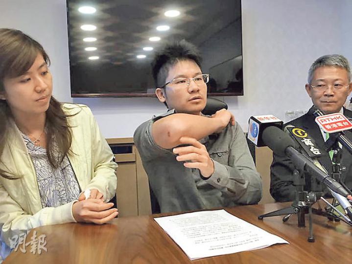 喜記老闆廖偉文（中）喺老婆（左）同律師（右）陪同下開記者會，聲稱上星期五跌落地後身體多處受傷，展示手、腳、耳後等傷勢，仲話要睇兩次醫生，跌一下會嚴重到食飯都有難度，只可以飲奶。（何曉勤攝）