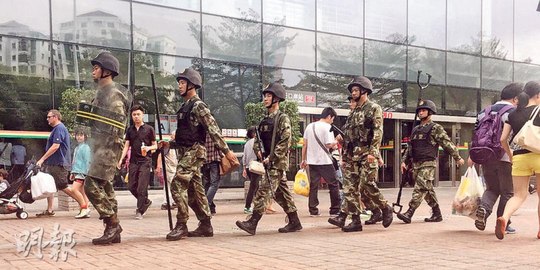 有傳內地水貨客號召於福田口岸大樓外示威,抗議一周一行安排,深圳警方昨日午開始已到場戒備,巡邏的警員更帶備盾牌、長槍和長叉,列隊來回巡邏。(明報記者攝) 有傳內地水貨客號召於福田口岸大樓外示威,抗議一周一行安排,深圳警方昨日午開始已到場戒備,巡邏的警員更帶備盾牌、長槍和長叉,列隊來回巡邏。(明報記者攝)