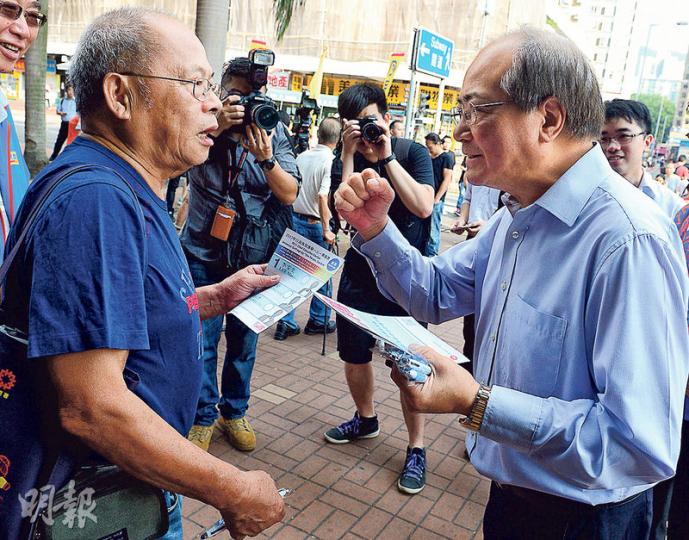 教育局長吳克儉(右)昨晨到大圍派政改宣傳單張,其間發生派報員被警指阻街的小風波。(劉焌陶攝) 教育局長吳克儉(右)昨晨到大圍派政改宣傳單張,其間發生派報員被警指阻街的小風波。(劉焌陶攝)