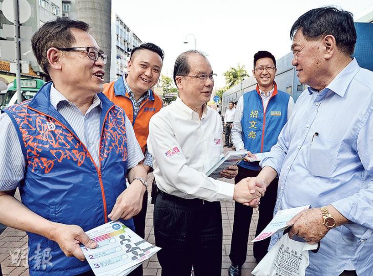 勞工及福利局長張建宗(中)昨日傍晚到大圍派發政改單張,多名民建聯沙田區議員如彭長緯(左起)、李世榮及招文亮等,全部人都穿起政黨背心,4人更一同圍着一名市民宣傳政改,而非各自派單張。(盧翊銘攝) 勞工及福利局長張建宗(中)昨日傍晚到大圍派發政改單張,多名民建聯沙田區議員如彭長緯(左起)、李世榮及招文亮等,全部人都穿起政黨背心,4人更一同圍着一名市民宣傳政改,而非各自派單張。(盧翊銘攝)