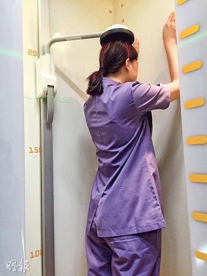 「3D X光機」掃描約需4分鐘,病人先要走入裝置度準位置,再站直和舉起兩手,便可掃描頸至小腿位置,實際拍攝時間只需7秒。(劉卓瑩攝) 「3D X光機」掃描約需4分鐘,病人先要走入裝置度準位置,再站直和舉起兩手,便可掃描頸至小腿位置,實際拍攝時間只需7秒。(劉卓瑩攝)