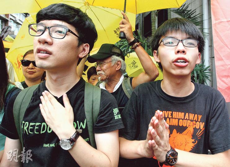 學聯秘書長羅冠聰(左)和學民思潮召集人黃之鋒(右)昨在律師陪同下到西區警署接受預約拘捕。(李紹昌攝) 學聯秘書長羅冠聰(左)和學民思潮召集人黃之鋒(右)昨在律師陪同下到西區警署接受預約拘捕。(李紹昌攝)