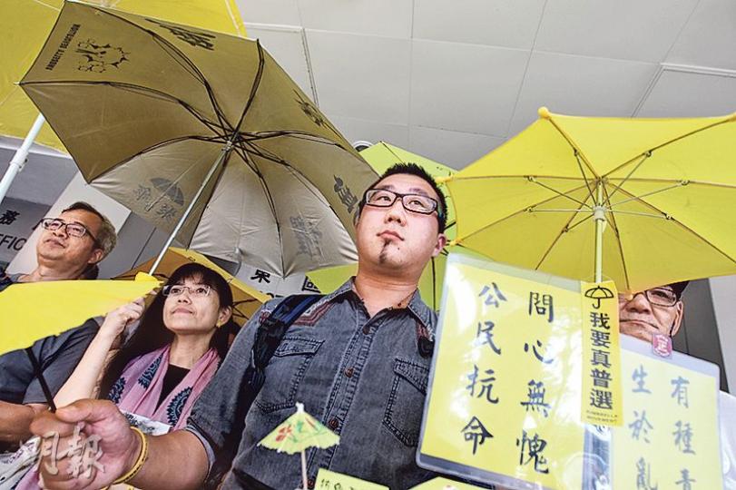 歐陽東(圖)在立法會議員馮檢基等伴隨下步出法院,撐起黃傘高呼口號。他稱身為藝術家面對社會議題,或會犧牲性命或挑戰法律灰色地帶,站出來抗命。(李紹昌攝) 歐陽東(圖)在立法會議員馮檢基等伴隨下步出法院,撐起黃傘高呼口號。他稱身為藝術家面對社會議題,或會犧牲性命或挑戰法律灰色地帶,站出來抗命。(李紹昌攝)