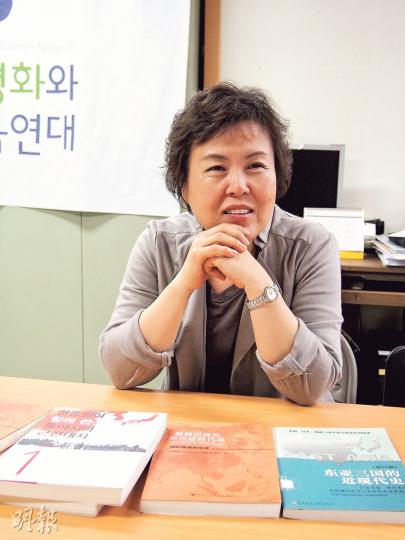 韓國民間教科書關注組織「亞洲和平及歷史教育連帶」常任共同運營委員長梁美康向記者介紹桌上由中日韓3國學者編著的歷史教科書,坦言14年來工作漫長艱辛,但自己從中得益不少。(林康琪攝) 韓國民間教科書關注組織「亞洲和平及歷史教育連帶」常任共同運營委員長梁美康向記者介紹桌上由中日韓3國學者編著的歷史教科書,坦言14年來工作漫長艱辛,但自己從中得益不少。(林康琪攝)