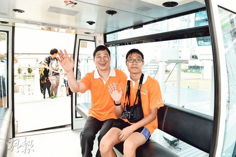 香港傷健共融網絡有限公司主席莫儉榮(前左)及兒子莫早謙(右)將一齊參加街馬活動,昨日練跑後一齊乘坐中環摩天輪。(陳淑安攝) 香港傷健共融網絡有限公司主席莫儉榮(前左)及兒子莫早謙(右)將一齊參加街馬活動,昨日練跑後一齊乘坐中環摩天輪。(陳淑安攝)