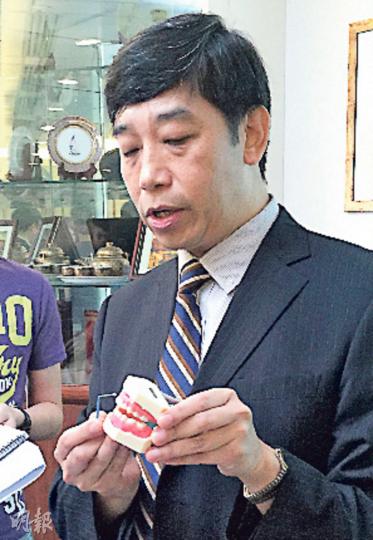 港大牙醫學院牙科公共衛生講座教授盧展民以牙齒模型展示氟化銀溶液治療過程。(劉琪琦攝) 港大牙醫學院牙科公共衛生講座教授盧展民以牙齒模型展示氟化銀溶液治療過程。(劉琪琦攝)