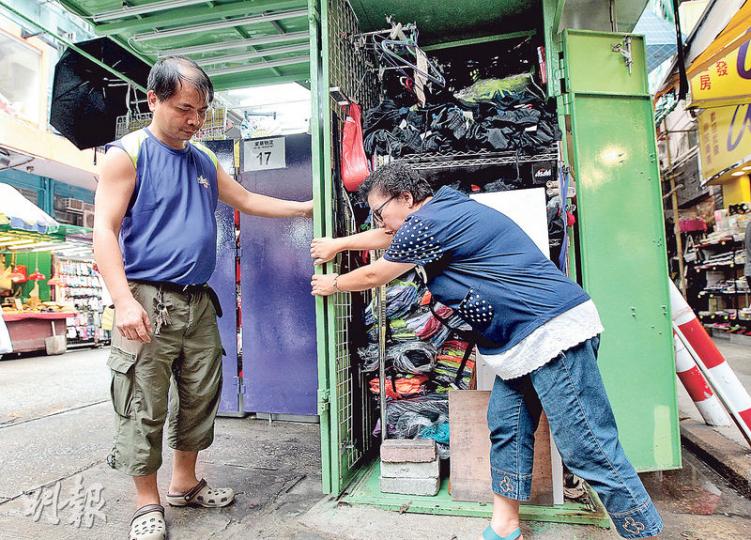 花園街排檔檔主潘太(右)與助手合力才能「收檔」,她指裝修手工大有問題,接口位不整齊,食環署亦指物料厚度不合規格,她要求承辦商退回訂金。(李澤彤攝) 花園街排檔檔主潘太(右)與助手合力才能「收檔」,她指裝修手工大有問題,接口位不整齊,食環署亦指物料厚度不合規格,她要求承辦商退回訂金。(李澤彤攝)