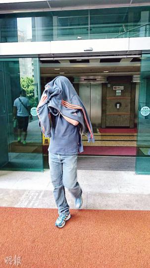 被告劉偉文為前偵緝警員,他昨獲准保釋候訊,離開法庭時用外套蓋頭。(張梓鈴攝) 被告劉偉文為前偵緝警員,他昨獲准保釋候訊,離開法庭時用外套蓋頭。(張梓鈴攝)
