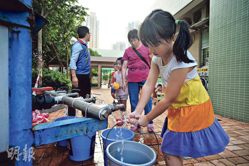 政府驗出馬鞍山欣安邨食水含鉛量超標,昨日安排水箱及水車向邨民派水,亦有工程人員將邨外食水管臨時駁入屋邨。圖為一名女孩用水桶載水回家。(蘇智鑫攝) 政府驗出馬鞍山欣安邨食水含鉛量超標,昨日安排水箱及水車向邨民派水,亦有工程人員將邨外食水管臨時駁入屋邨。圖為一名女孩用水桶載水回家。(蘇智鑫攝)